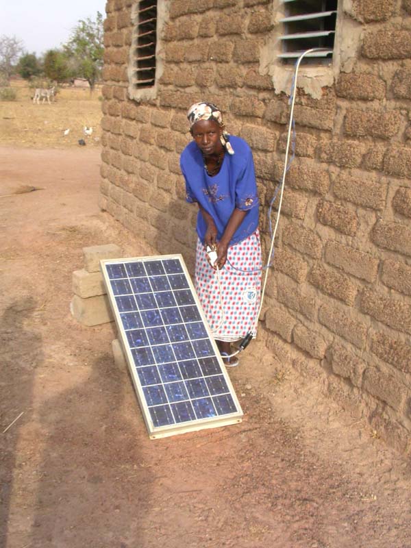 La présidente branche la nouvelle plaque solaire qui doit recharger la batterie de la laiterie